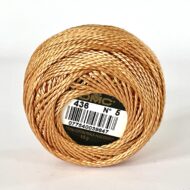 A DMC Cotton Perle 116 / 436 / 8 (Light Brown) ball of 100%, mercerised cotton thread that has been manufactured using a twisting process so it iis non-divisible.