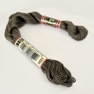 A DMC Cotton Perle in shade 3021 (size 5) skein of 100%, mercerised cotton embroidery thread manufactured using a twisting process so it is non-divisible.