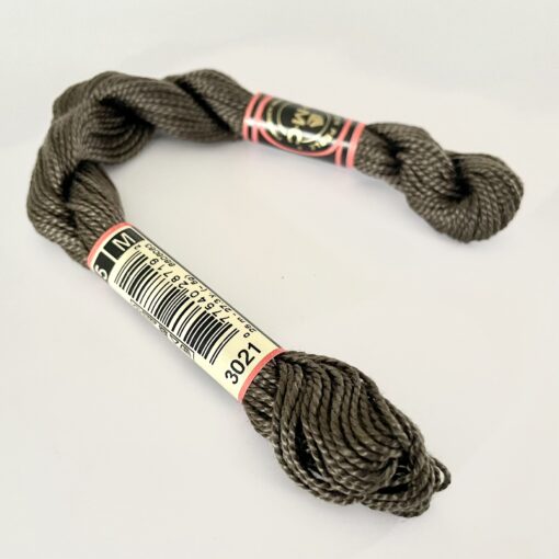 A DMC Cotton Perle in shade 3021 (size 5) skein of 100%, mercerised cotton embroidery thread manufactured using a twisting process so it is non-divisible.
