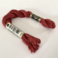 A DMC Cotton Perle in shade 355 (size 3) skein of 100%, mercerised cotton embroidery thread manufactured using a twisting process so it is non-divisible.