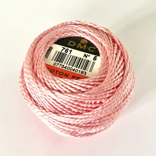 A DMC Cotton Perle 116 / 761/ 5 ball of 100%, pink, mercerised cotton thread that has been manufactured using a twisting process so it is non-divisible.
