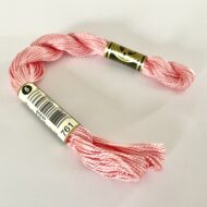 A DMC Cotton Perle in shade 761 (size 3) skein of 100%, mercerised cotton embroidery thread manufactured using a twisting process so it is non-divisible.
