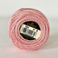 A DMC Cotton Perle 116 / 761/ 8 ball of 100%, pink, mercerised cotton thread that has been manufactured using a twisting process so it is non-divisible.