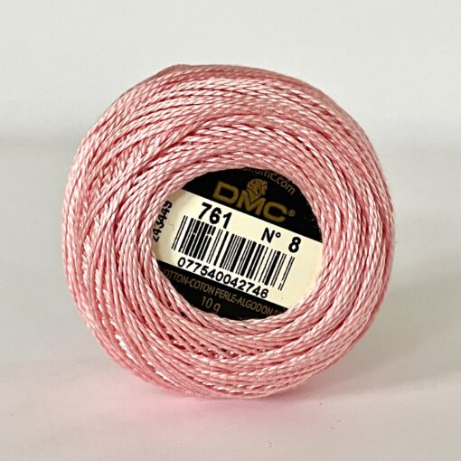 A DMC Cotton Perle 116 / 761/ 8 ball of 100%, pink, mercerised cotton thread that has been manufactured using a twisting process so it is non-divisible.