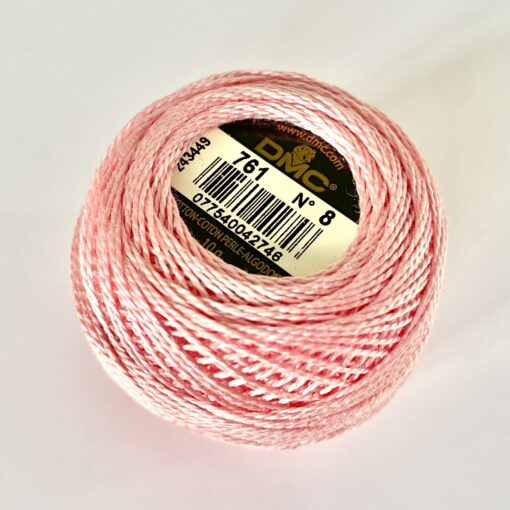 A DMC Cotton Perle 116 / 761/ 8 ball of 100%, pink, mercerised cotton thread that has been manufactured using a twisting process so it is non-divisible.