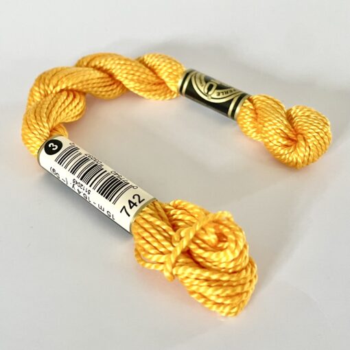 A DMC Cotton Perle in shade 742 (size 3) skein of 100%, mercerised cotton embroidery thread manufactured using a twisting process so it is non-divisible.