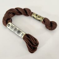 A DMC Cotton Perle in shade 938 (size 3) skein of 100%, mercerised cotton embroidery thread manufactured using a twisting process so it is non-divisible.